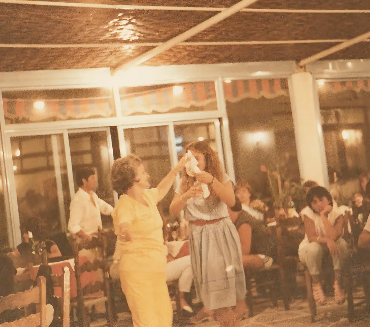 The mantili raised between two hands at the taverna